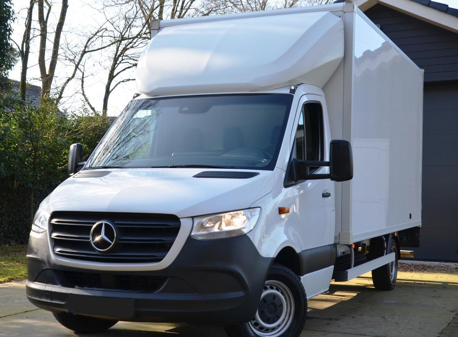 Ein junger Mann sitzt auf dem Fahrersitz eines weißen Lieferwagens.