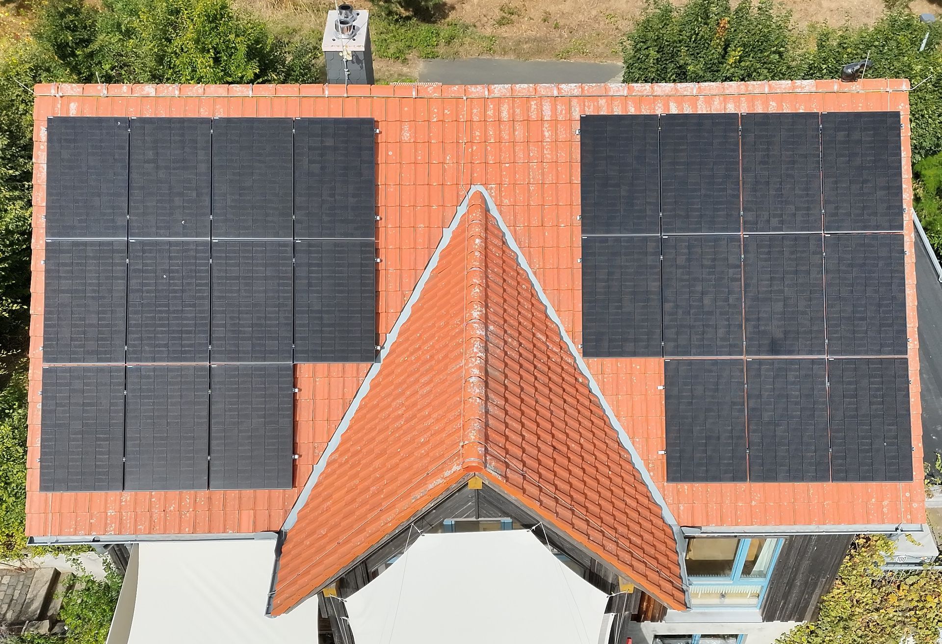 Solarmodule und eine Windturbine unter blauem Himmel stehen für erneuerbare Energie.