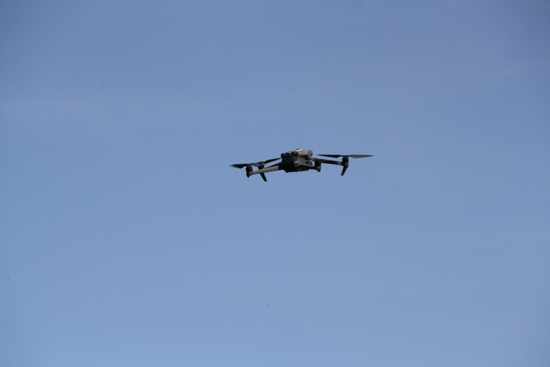 Drohne fliegt in einem klaren blauen Himmel.