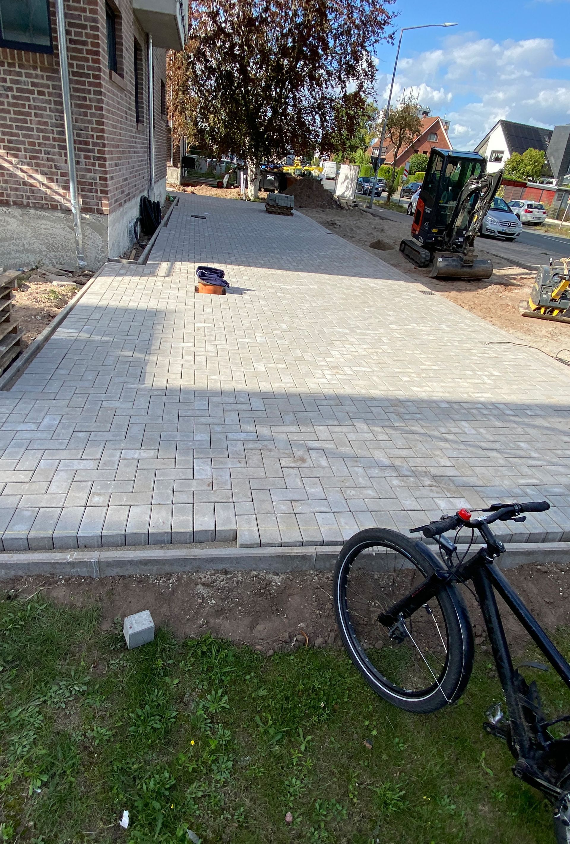 Vor einem im Bau befindlichen Gebäude steht ein Fahrrad.
