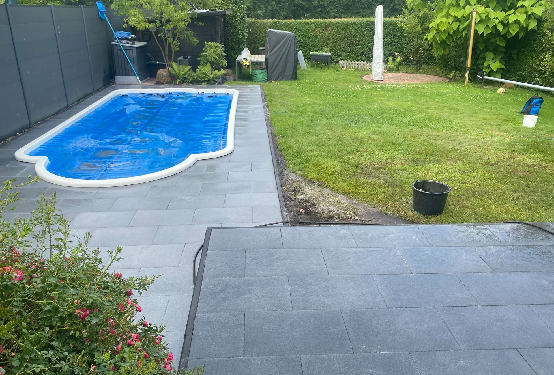 Ein großer Swimmingpool befindet sich inmitten eines üppig grünen Gartens.