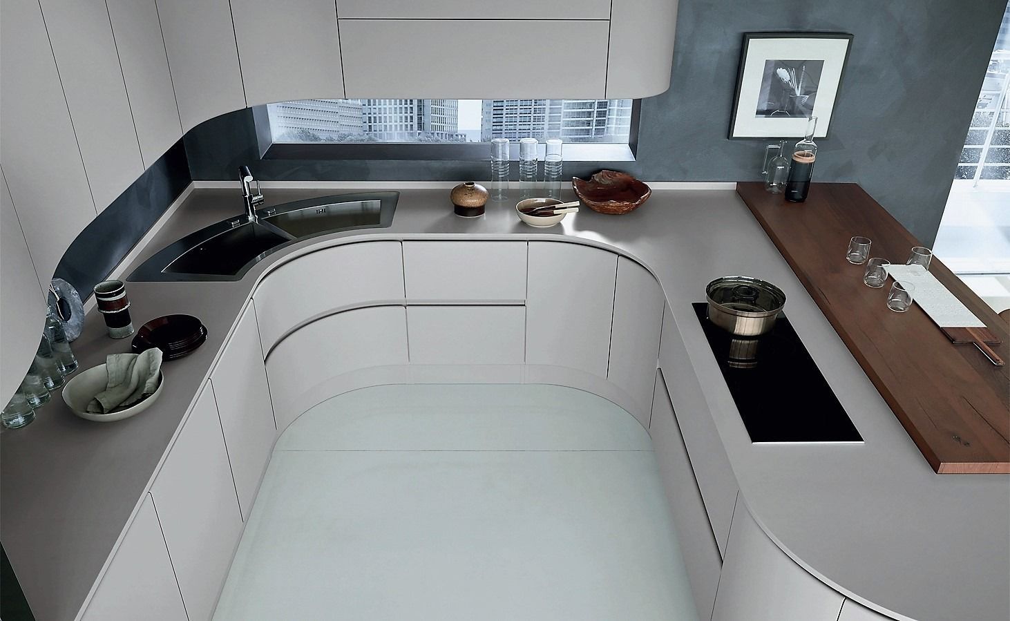 Cocina moderna con gabinetes blancos curvos, encimeras negras, fregadero y ventana sobre el fregadero.