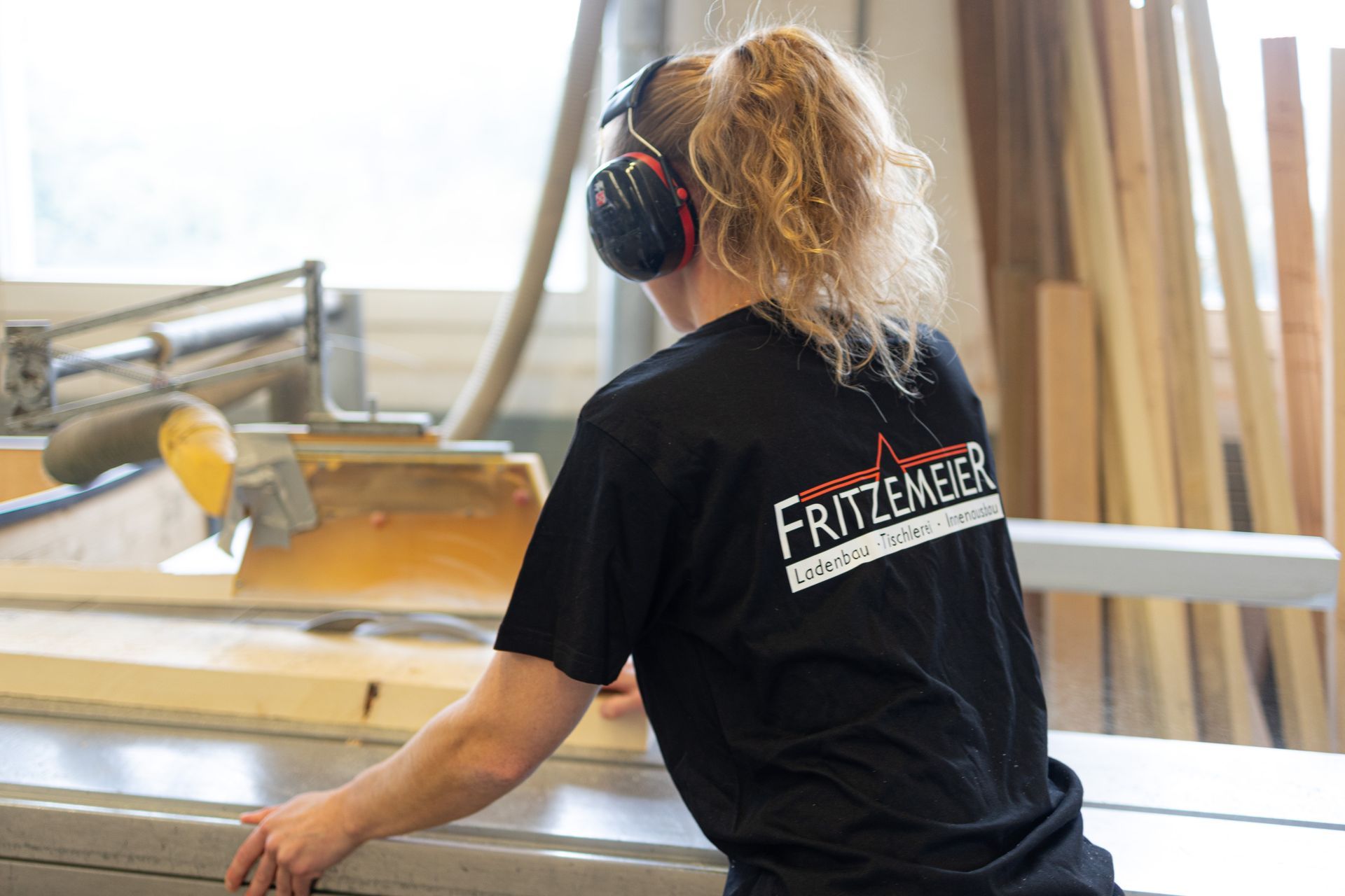 Mitarbeiterin der Tischlerei Fritzemeier GmbH beim Schneiden von Holz
