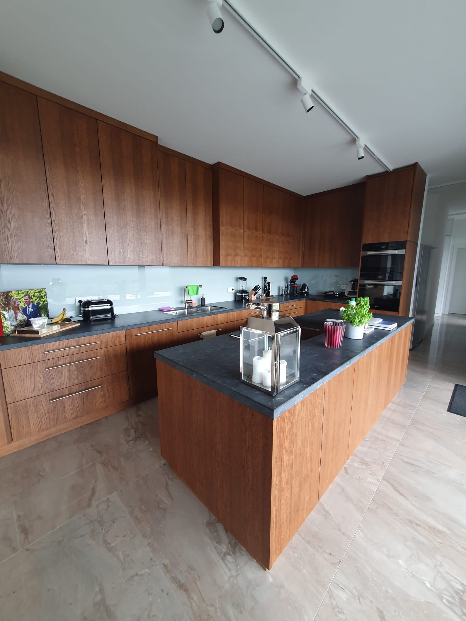 Küche mit Kücheninsel in einem dunklen Rotbraun mit schwarzer Arbeitsfläche