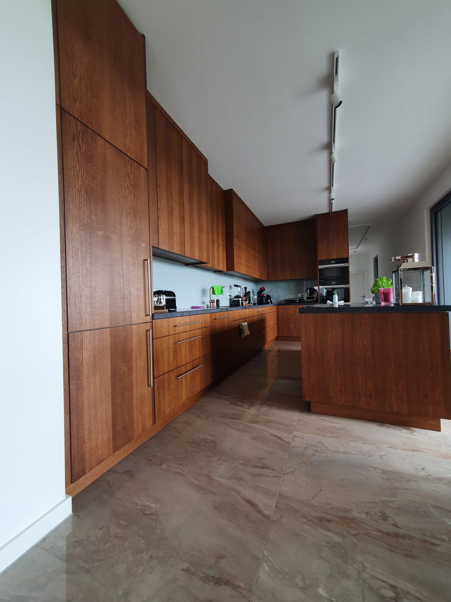 Küche mit Kücheninsel in einem dunklen Rotbraun mit schwarzer Arbeitsfläche