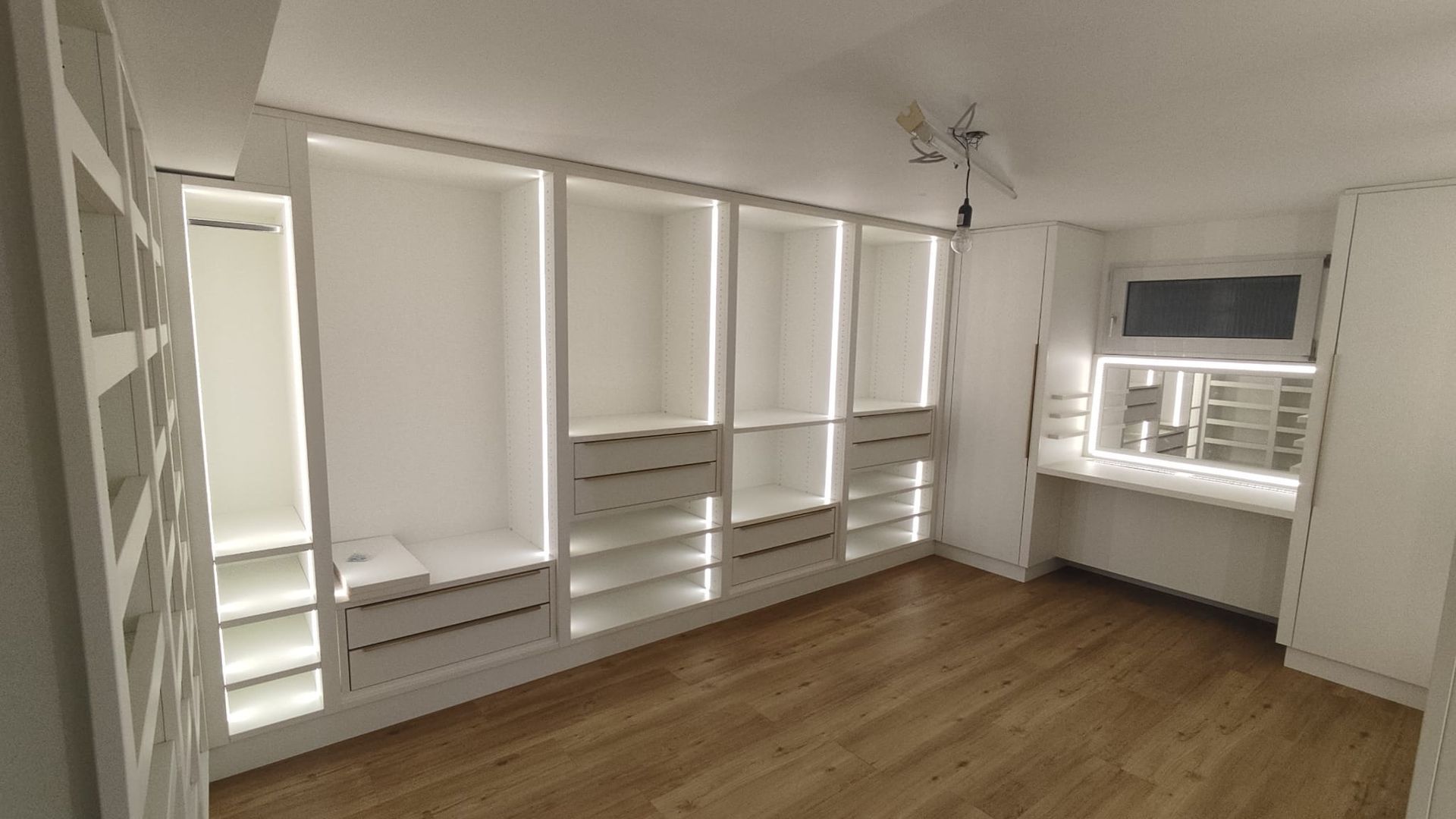 Begehbarer Kleiderschrank mit beleuchteten Regalen und Spiegeln