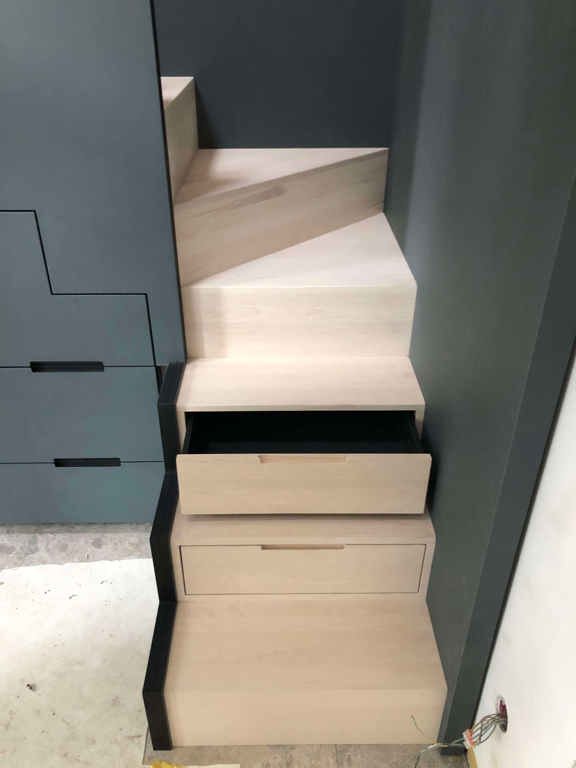 Treppe mit integrierten Regalen und Schubfächern unter der Treppe und in den Stufen