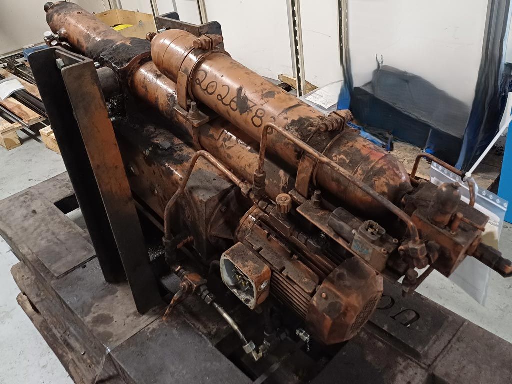 Centrale hydraulique industrielle rouillée, montée sur une palette de transport en bois