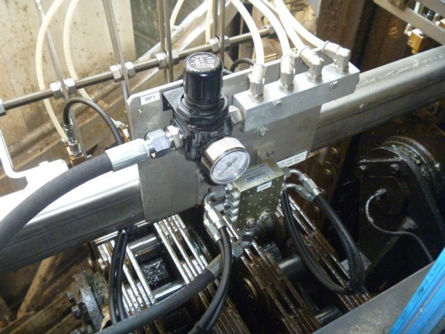 Machines industrielles comprenant un régulateur de pression pneumatique, un manomètre et un collecteur avec tuyauterie raccordée.