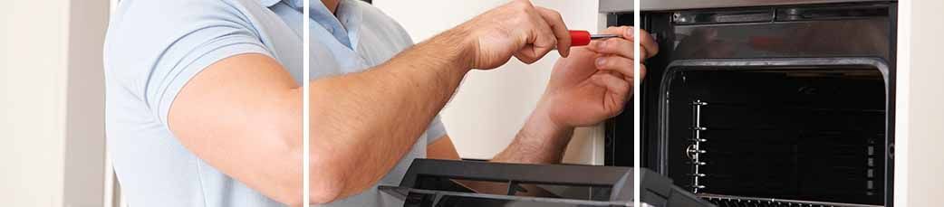 Un hombre está arreglando un microondas con un destornillador.