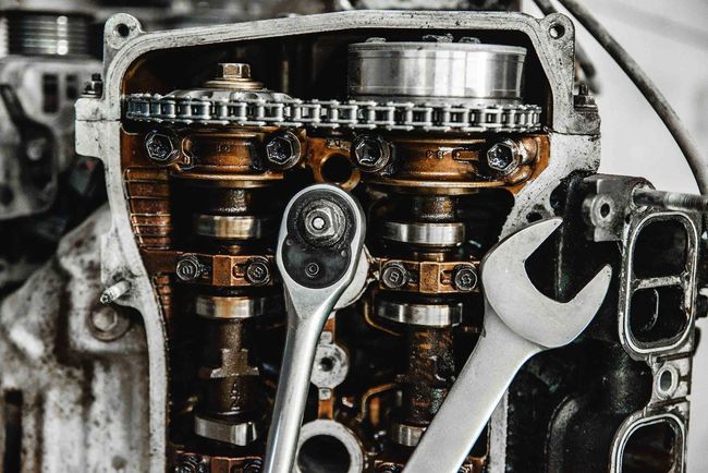 Un primer plano de un motor de automóvil con una llave inglesa sobre él.
