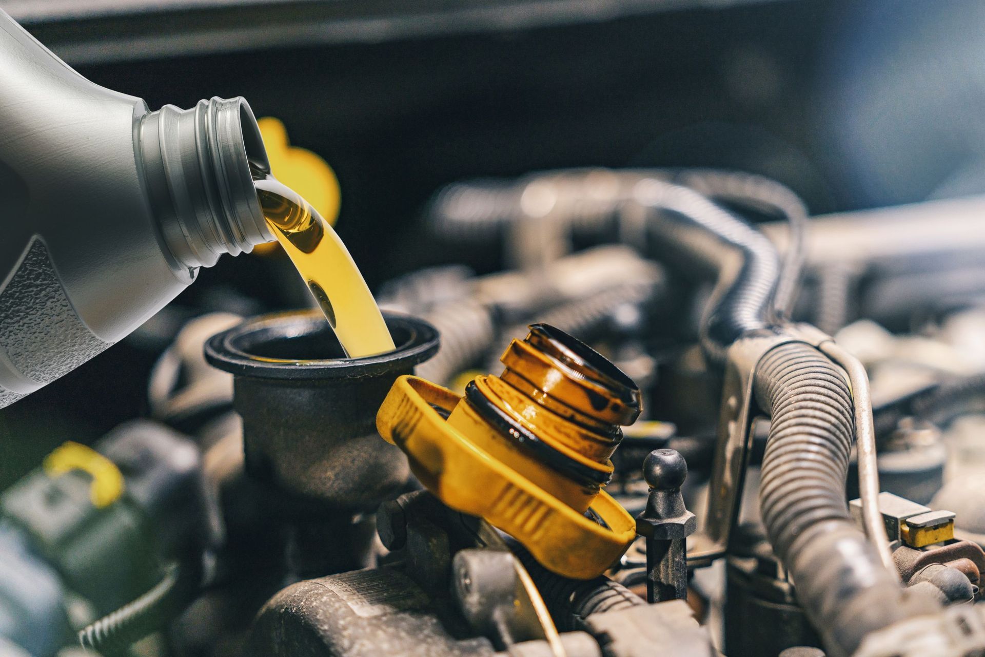 Se vierte una botella de aceite en el motor de un automóvil.