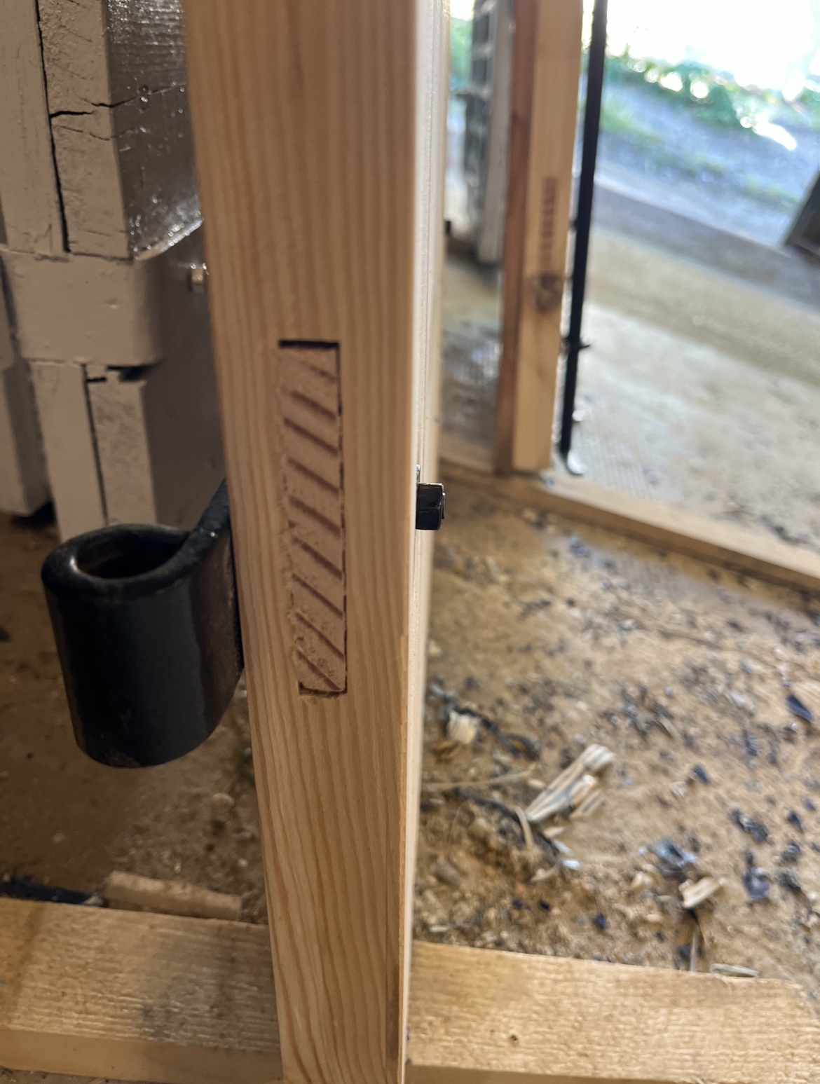 Gros plan sur la tranche d'un volet en bois présentant un assemblage à queue-d’aronde. L'assemblage est ouvert, laissant apparaître le motif.