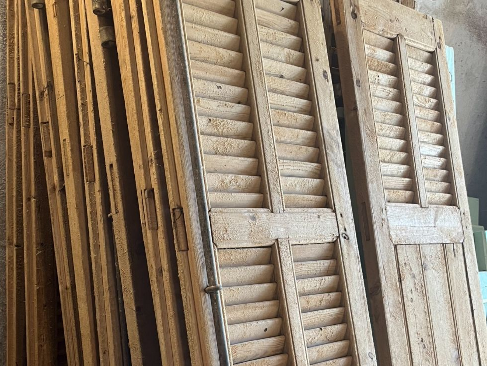 Un tas de volets en bois patinés par le temps.