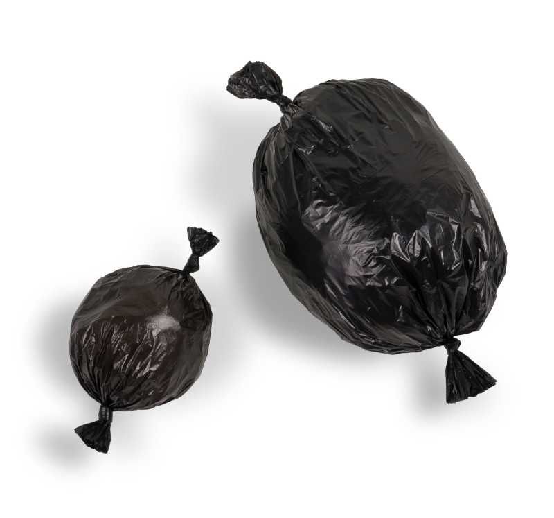 Zwei schwarze Müllsäcke sind auf einem weißen Hintergrund zusammengebunden.
