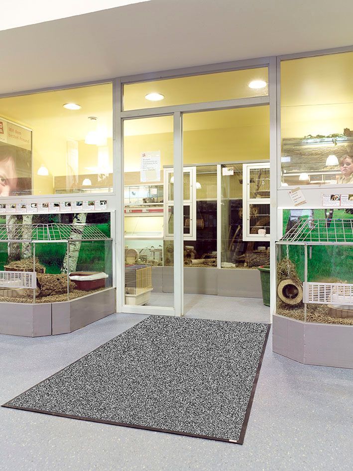 Eine Ladenfront mit einem Teppich davor