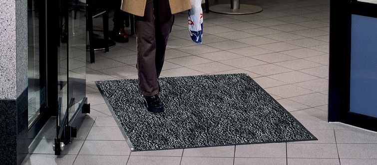 Eine Person, die auf einer Matte vor einer Glastür läuft