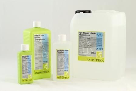 Drei Flaschen Antiseptikum stehen nebeneinander auf einem Tisch.