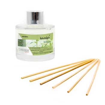 Eine Flasche Rattanstäbchen-Diffusor neben einem Bündel Holzstäbchen.