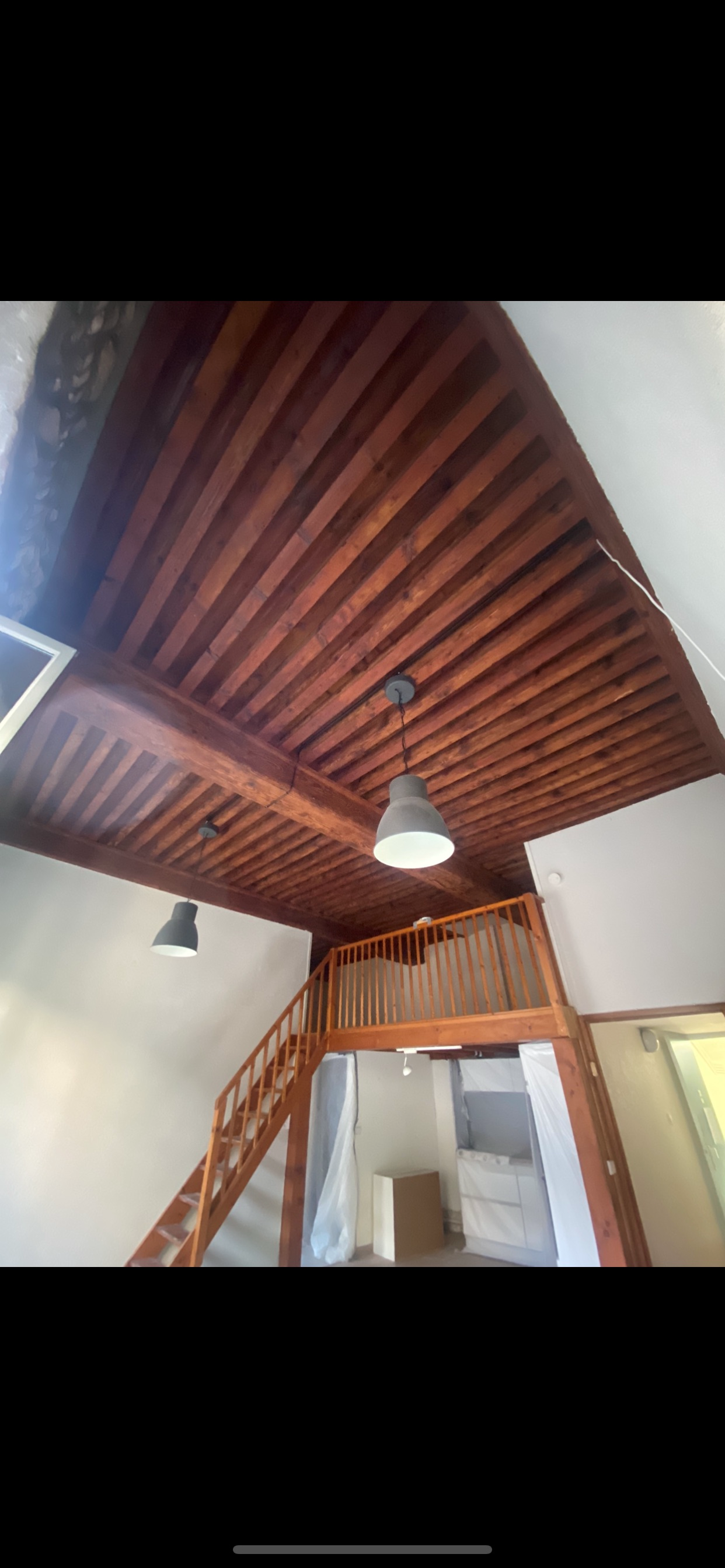 Plafond foncé en bois au-dessus d'une mezzannine