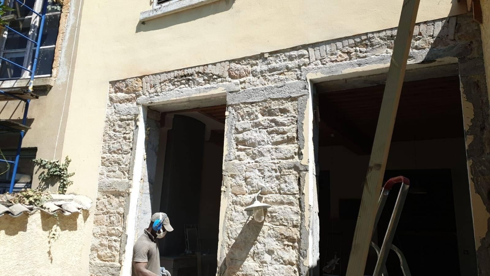 Artisan en train d'entretenir un mur en pierres