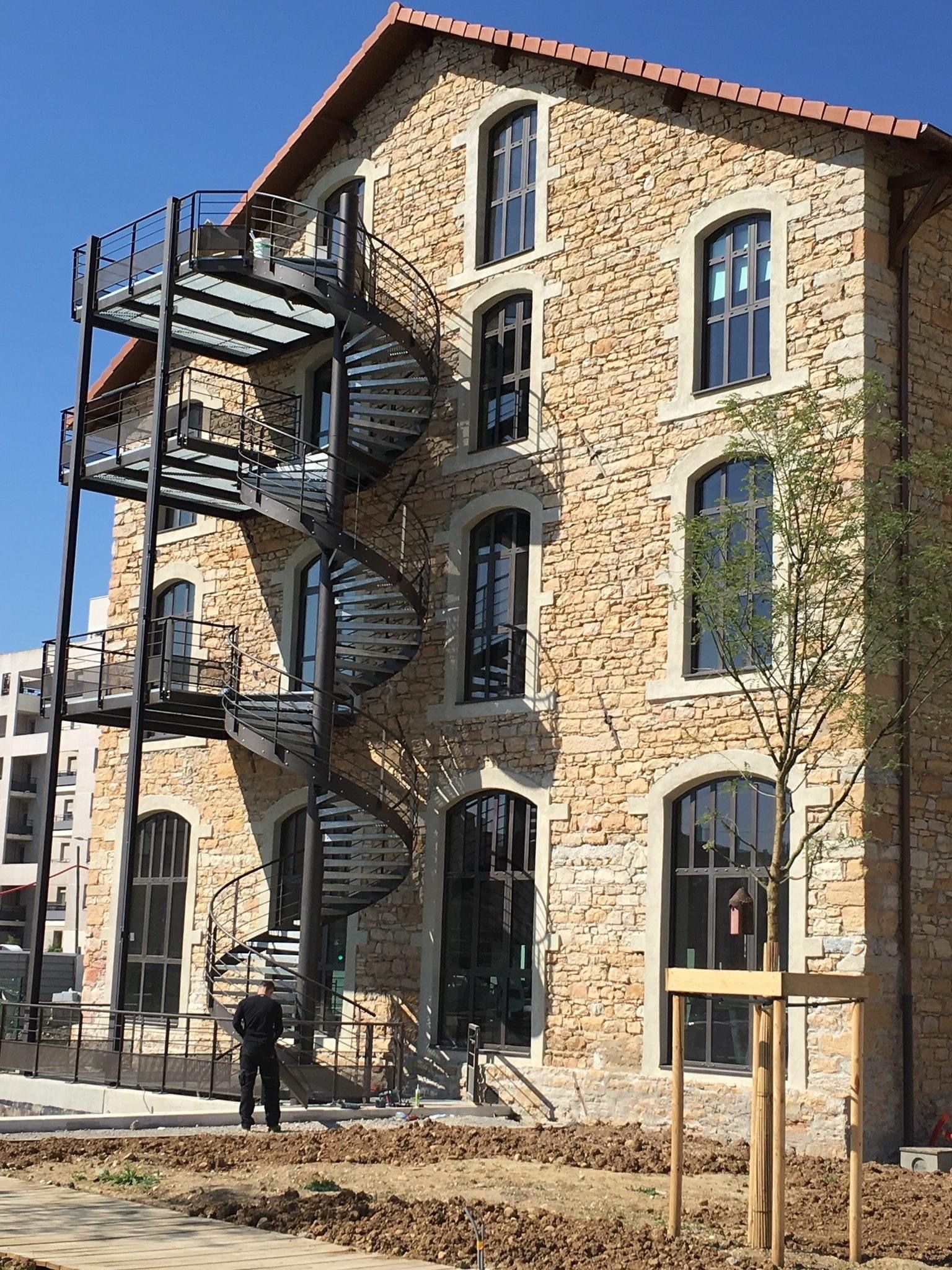 Escalier en fer le long d'un bâtiment en pierre