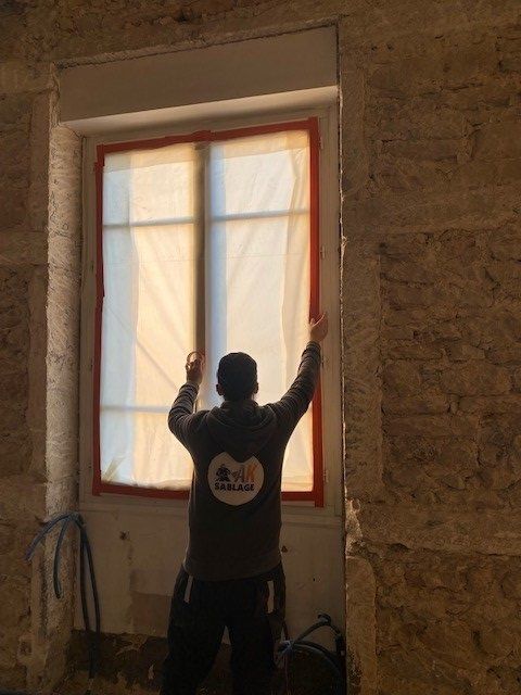 Artisan en train de protéger une fenêtre
