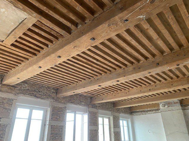 Maison ancienne en pierre et plafond en bois vue de l'intérieur