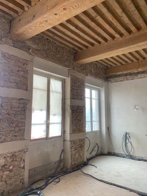 Mur en pierres entourant deux grandes fenêtres