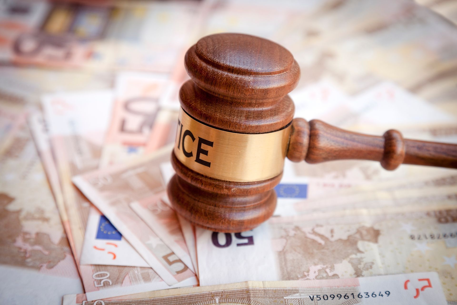 Mazo de madera sobre billetes de euro, con la palabra