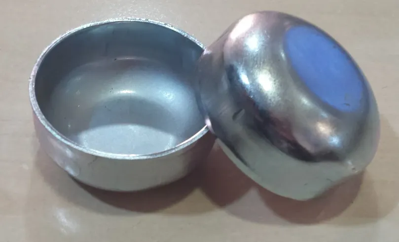 Dos cuencos de metal plateado, uno abierto y el otro de lado con el centro azul.