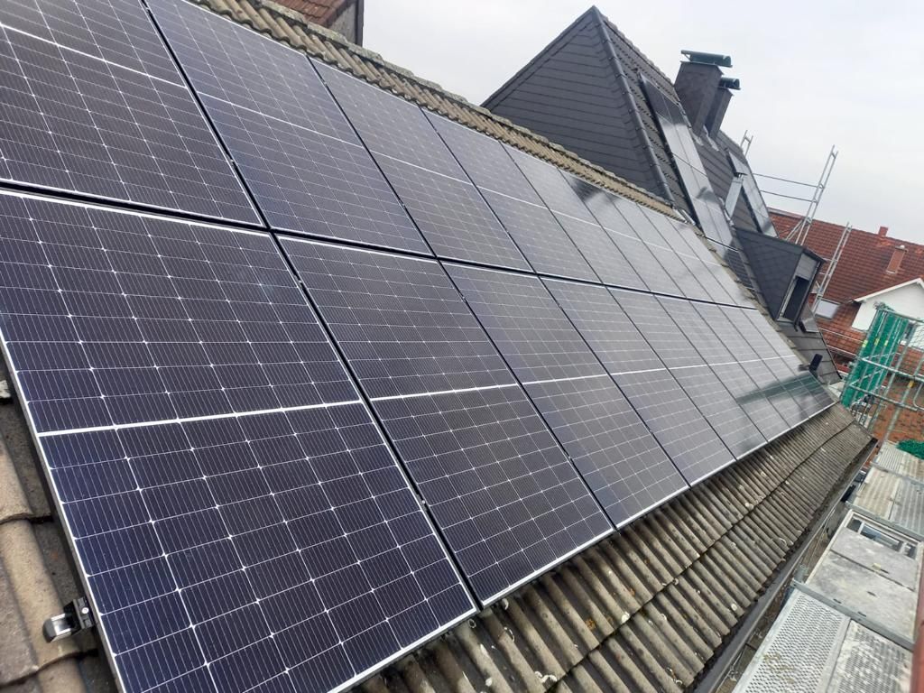 Auf einem dunkelgrauen Ziegeldach wurden Solarpaneele installiert.