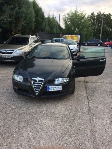 Un coche negro está aparcado en un estacionamiento con las puertas abiertas.