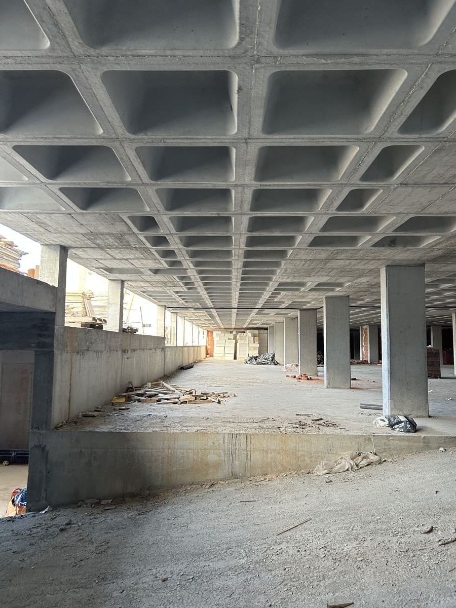 Techo de hormigón reticular en construcción con columnas y muros bajos.