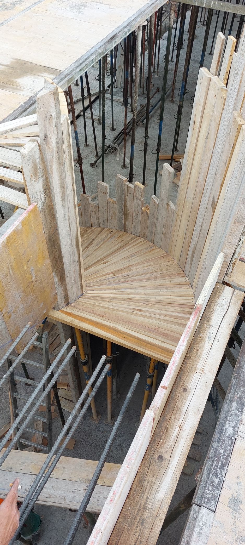 Obra de construcción con encofrados de madera y varillas de refuerzo para escaleras de hormigón.