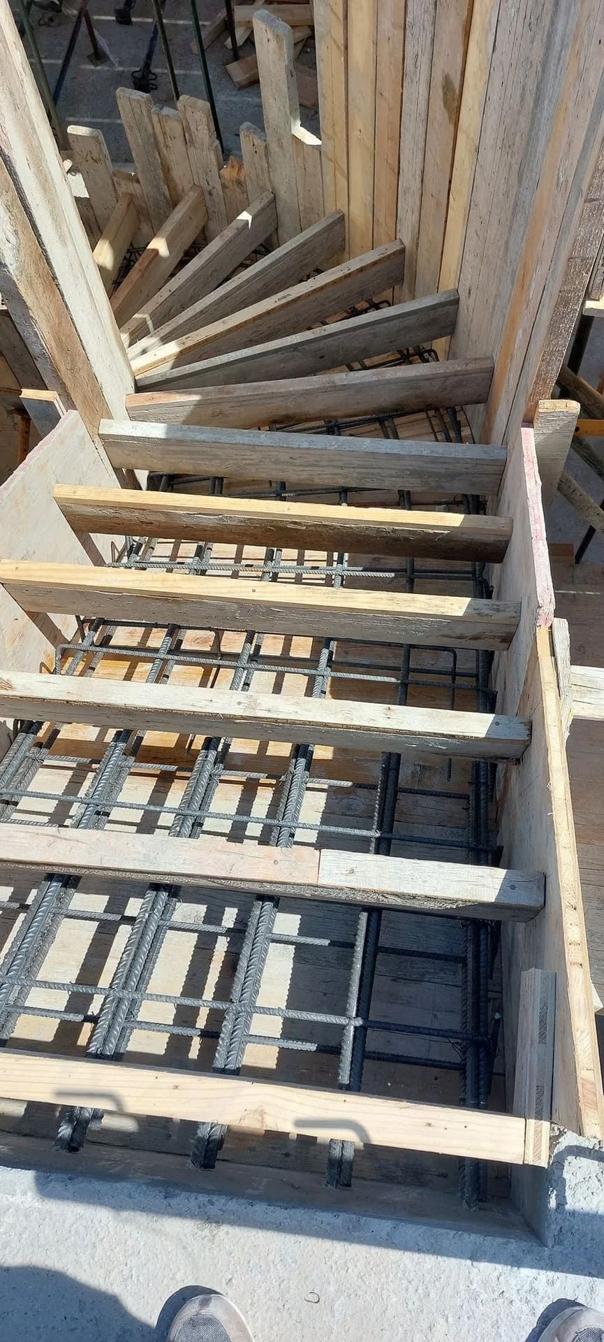 Escalera de caracol de madera en construcción, con refuerzo de varilla corrugada.