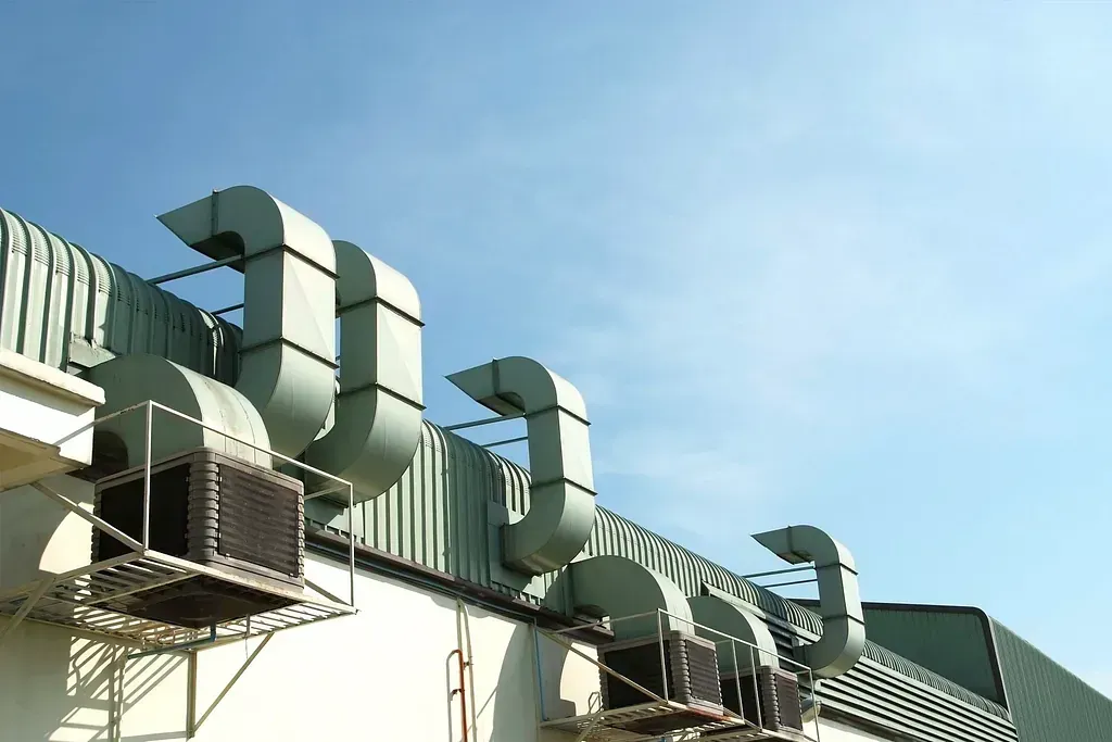 Un edificio con muchas tuberías saliendo de él.