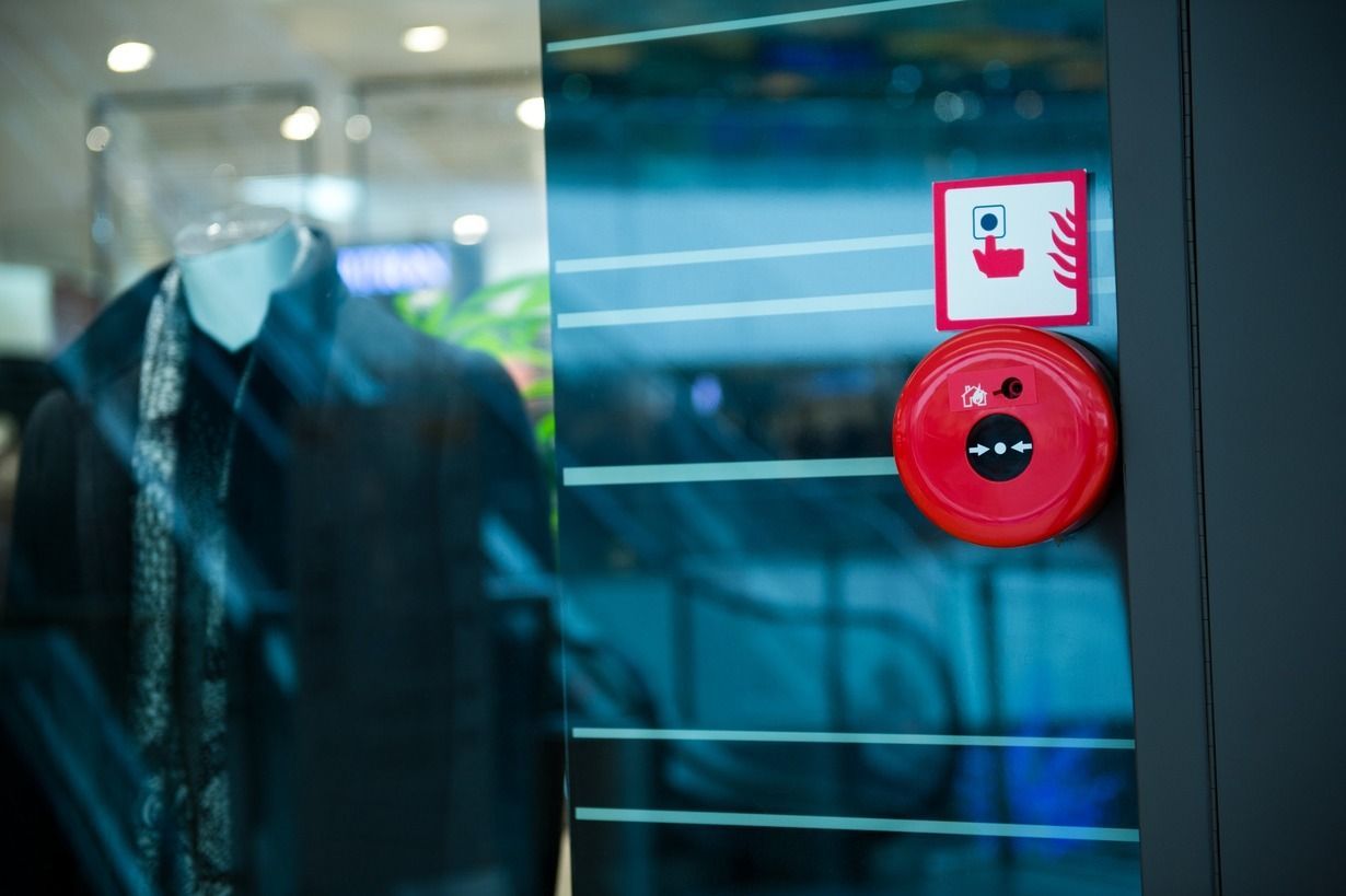 Una alarma de incendio roja está en una puerta de vidrio en una tienda.