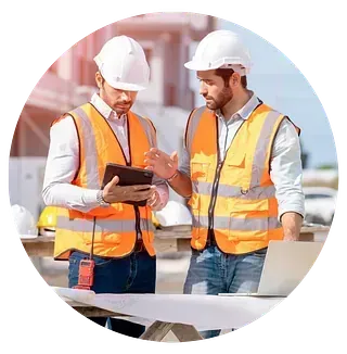 Dos trabajadores de la construcción miran una tableta en un sitio de construcción.