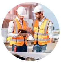 Dos trabajadores de la construcción miran una tableta en un sitio de construcción.