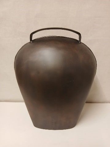 Eine braune Vase mit einem schwarz-weißen Muster darauf
