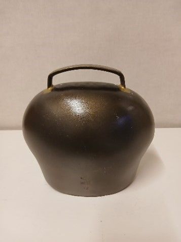 Eine schwarze Vase mit Blumen und einem Schild darauf