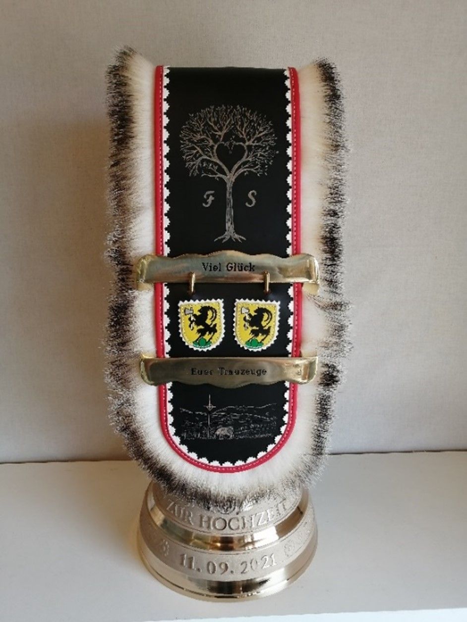 Eine Trophäe mit einem Baum und Schildern darauf