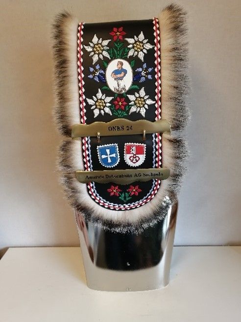 Eine silberne Glocke mit einem Bild eines Mannes darauf