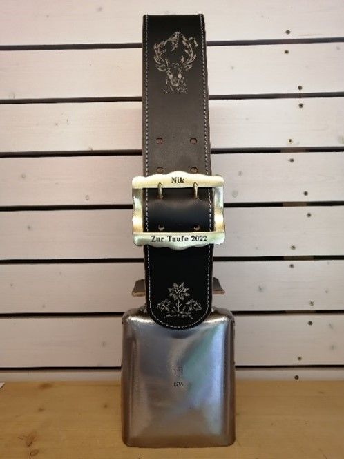 Ein schwarzer Gürtel mit weißer Schnalle und silberner Glocke