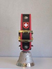 Auf einem Tisch steht eine Glocke mit einer Schweizer Flagge.