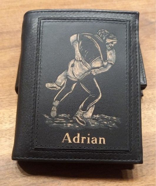 Eine schwarze Brieftasche mit dem Namen Adrian darauf