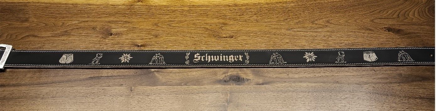 Auf einem Holztisch liegt ein schwarzes Maßband.