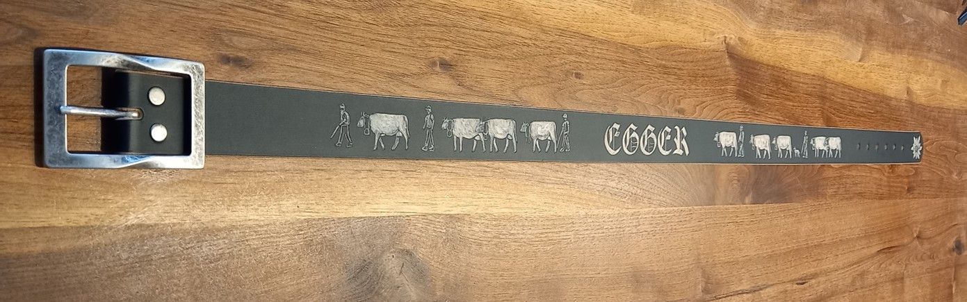 Ein grauer Gürtel mit einer silbernen Schnalle auf einer Holzoberfläche