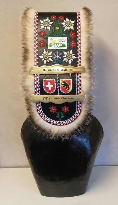 Auf einem Tisch liegt eine schwarze Glocke mit Pelzkragen.